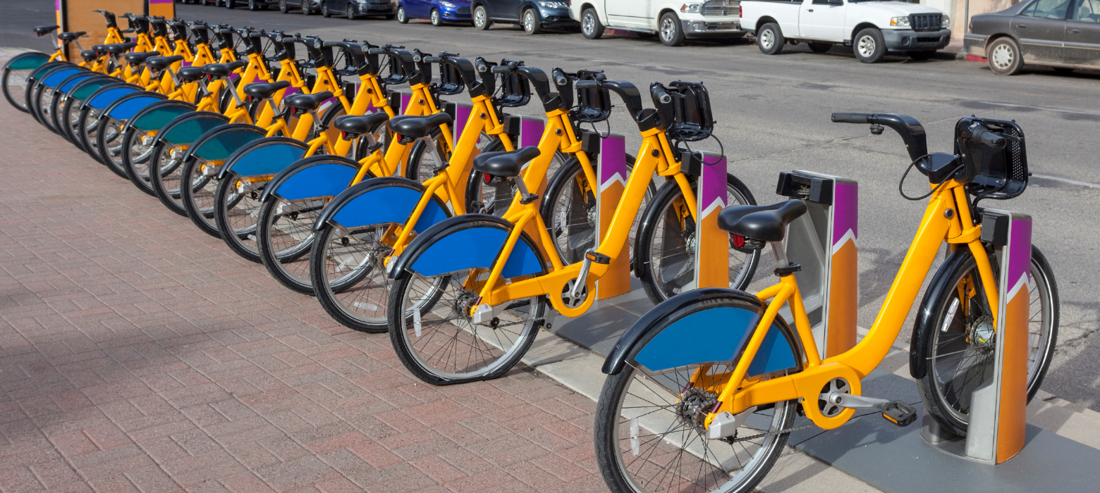 a row of yellow and blue bicycles parked next to each other city bike rental